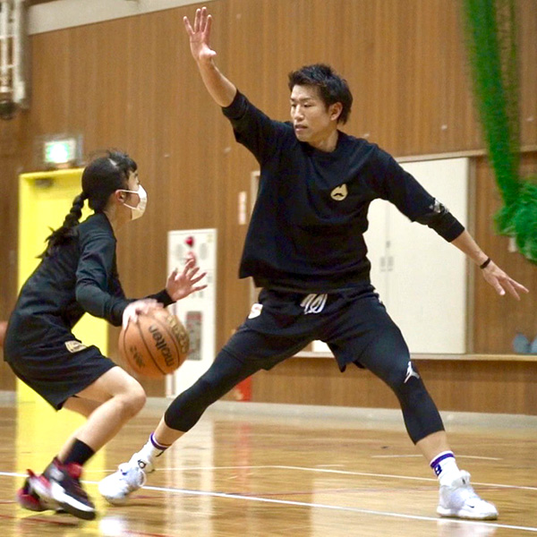 ディフェンスする飯島に向かってドリブルするココバスのスクール生